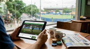 A player with his laptop or tablet on a coffee shop overseeing a sport event